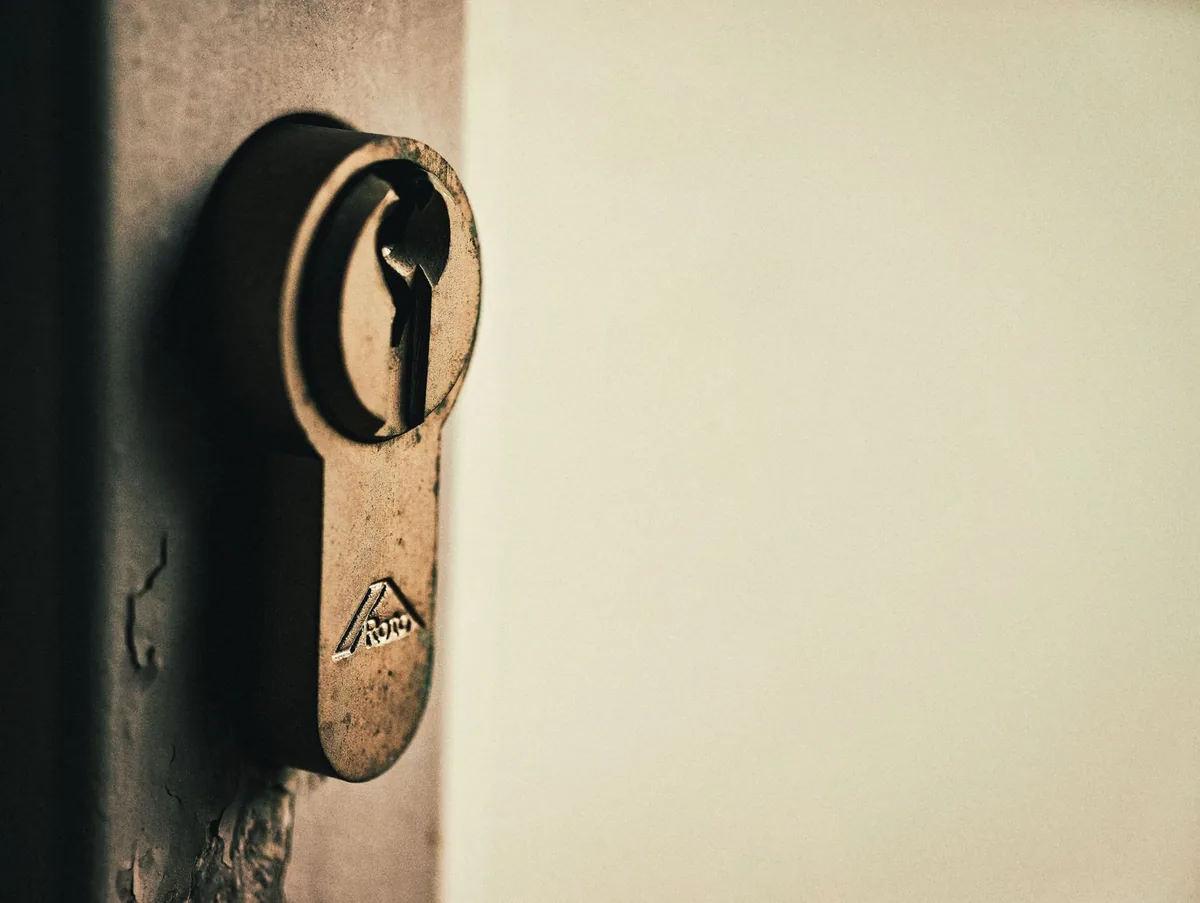 Close-up of vintage keyhole on a weathered wooden door, capturing rustic charm.