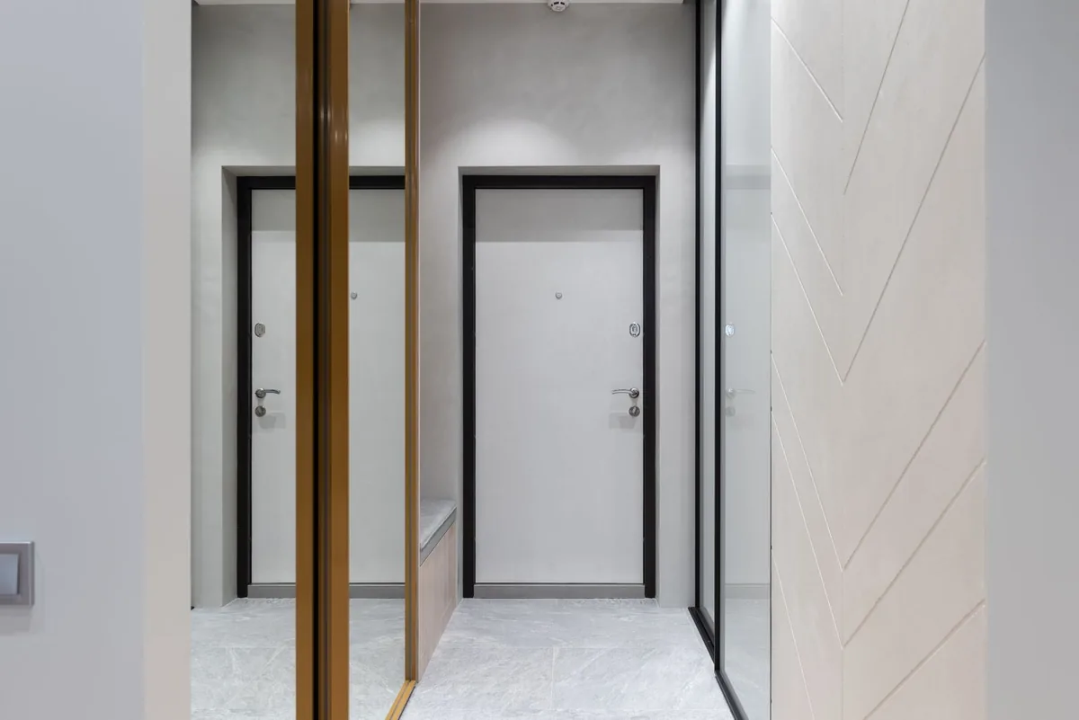 Perspective view of hall with white walls and wardrobes designed with mirrors